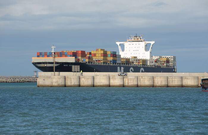 The car in the foreground is dwarfed by the size of the ship as it enters the Port of Ngqura